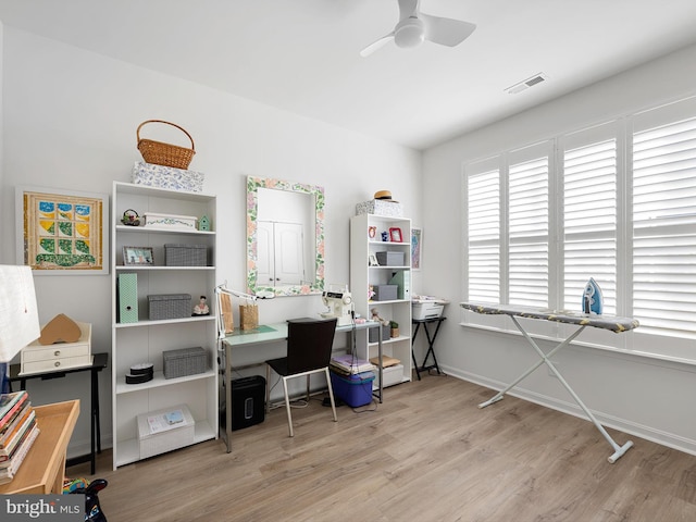 home office with ceiling fan and light hardwood / wood-style flooring