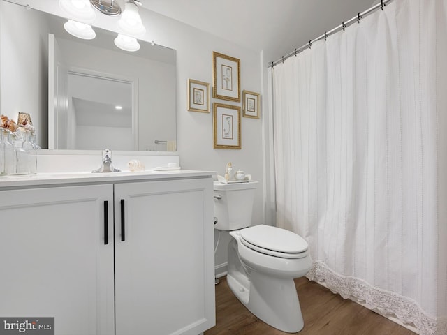 bathroom with vanity, toilet, and hardwood / wood-style floors