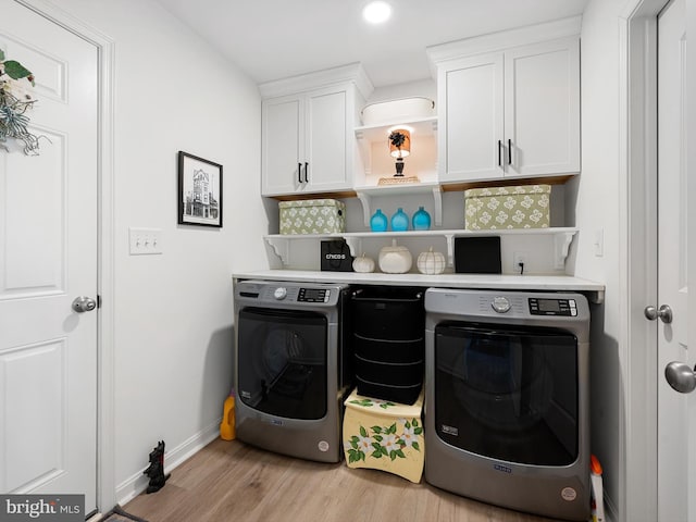 laundry room with cabinets, separate washer and dryer, and light hardwood / wood-style flooring