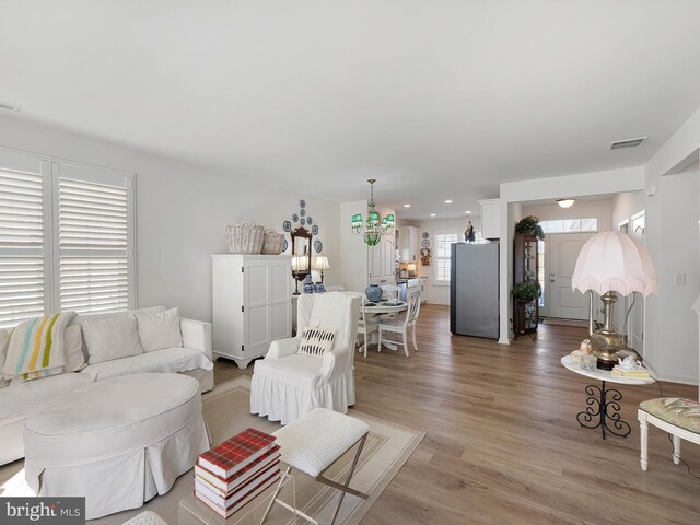 living room featuring a chandelier and light wood-type flooring