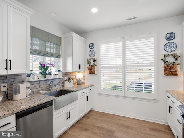 kitchen featuring light stone counters, dishwasher, tasteful backsplash, and white cabinets