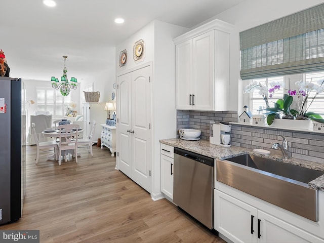 kitchen featuring light stone counters, stainless steel appliances, and white cabinets