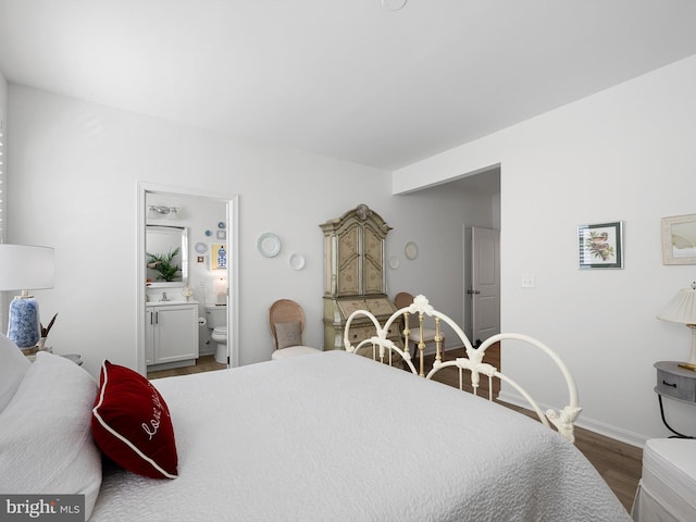 bedroom featuring ensuite bath and hardwood / wood-style floors