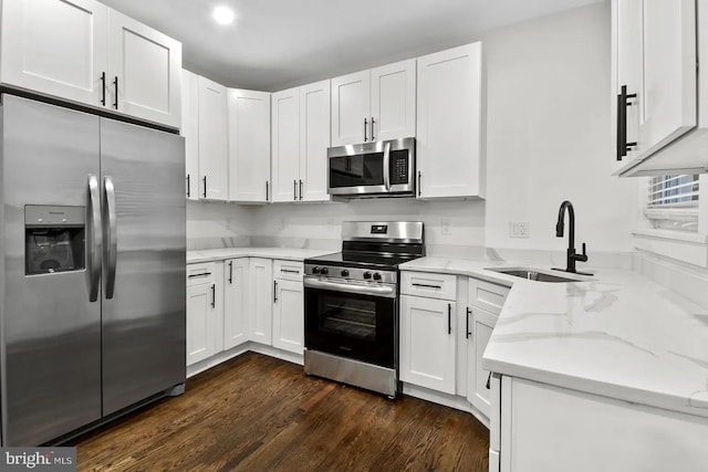 kitchen with sink, light stone counters, dark hardwood / wood-style flooring, stainless steel appliances, and white cabinets