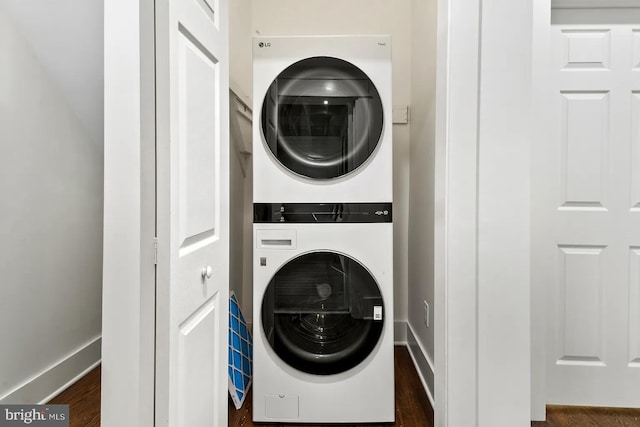 laundry room featuring dark hardwood / wood-style floors and stacked washer and clothes dryer