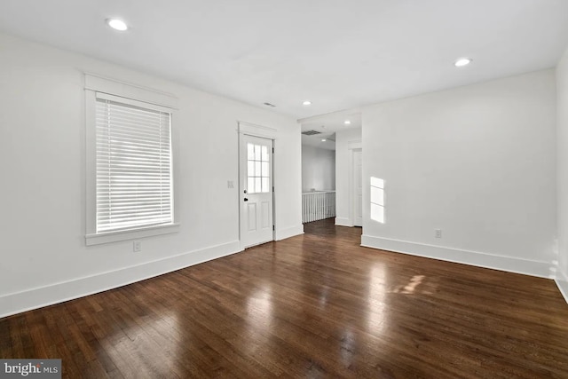 unfurnished room with dark wood-type flooring