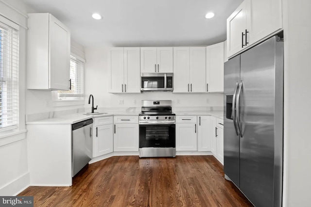 kitchen featuring white cabinetry, sink, dark wood-type flooring, and stainless steel appliances