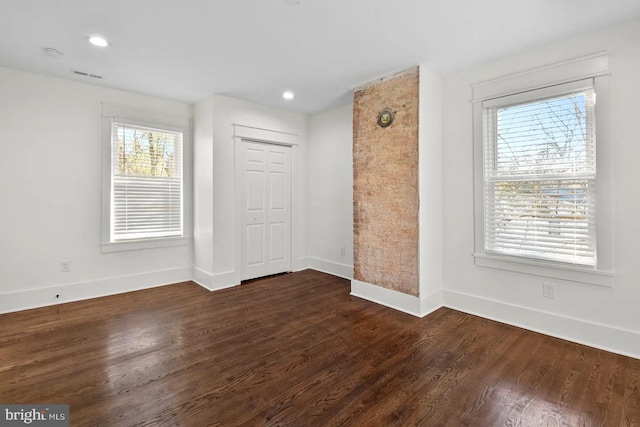 empty room with dark hardwood / wood-style flooring