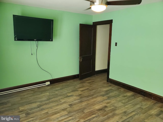 empty room with ceiling fan and dark hardwood / wood-style flooring