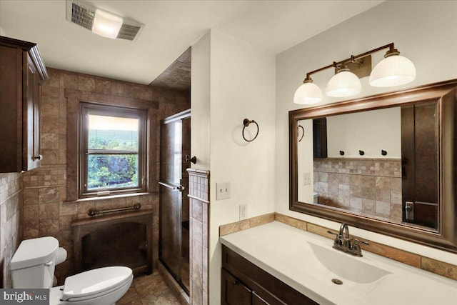 bathroom featuring vanity, tile walls, toilet, and walk in shower