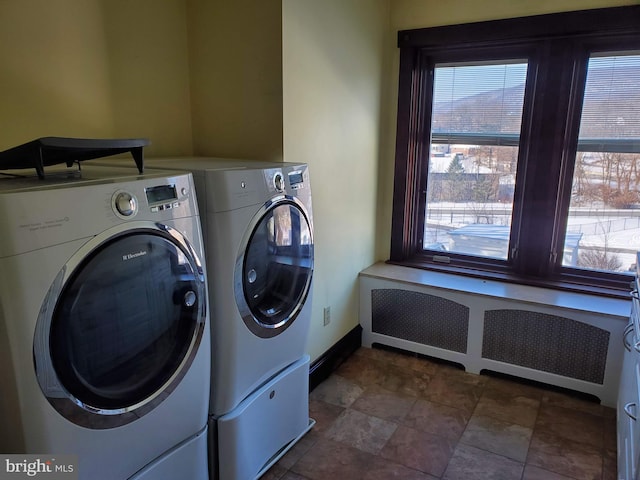 laundry area featuring radiator heating unit and washer and dryer