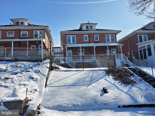 snow covered rear of property featuring a porch