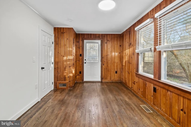 foyer featuring crown molding, dark hardwood / wood-style floors, and wood walls