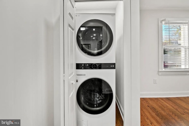 laundry room with stacked washer / dryer and hardwood / wood-style floors