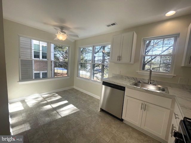 kitchen featuring a healthy amount of sunlight, sink, stainless steel dishwasher, and white cabinets