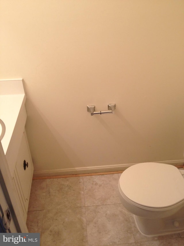 bathroom featuring vanity, tile patterned flooring, and toilet