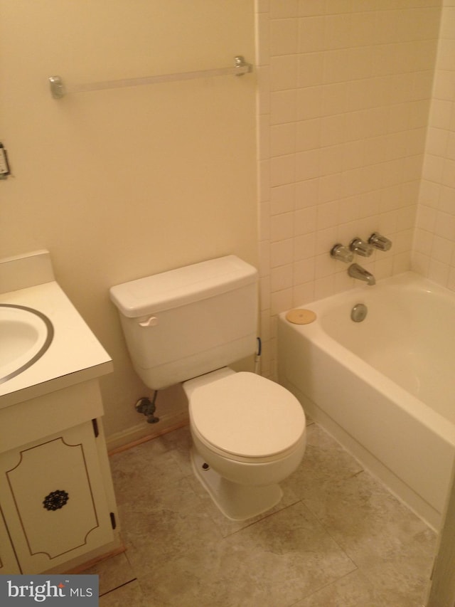 full bathroom with vanity, tiled shower / bath, and toilet