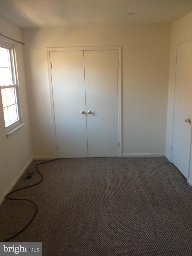 unfurnished bedroom featuring a closet and carpet