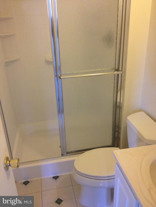 bathroom with walk in shower, tile patterned floors, toilet, and vanity