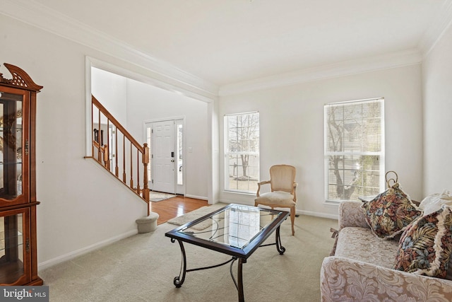 carpeted living area with stairs, crown molding, and baseboards