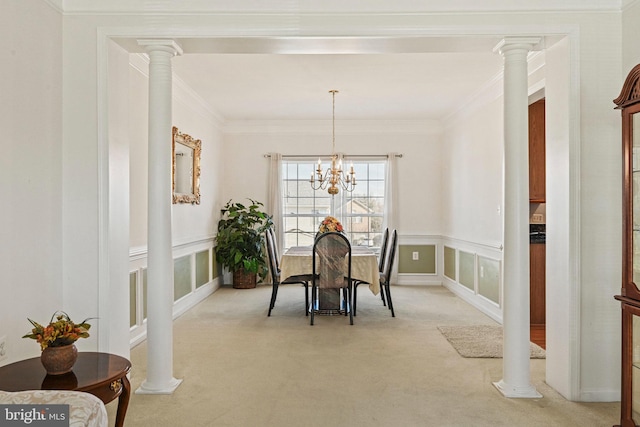 dining area featuring crown molding, a notable chandelier, ornate columns, and light carpet