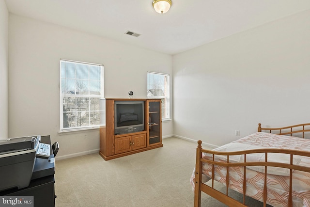 bedroom with multiple windows, light colored carpet, visible vents, and baseboards