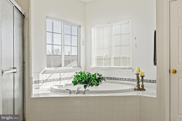 bathroom featuring a stall shower and a garden tub