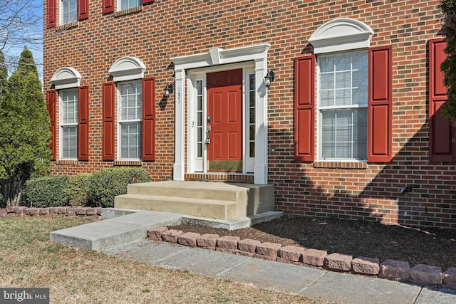 view of exterior entry featuring brick siding