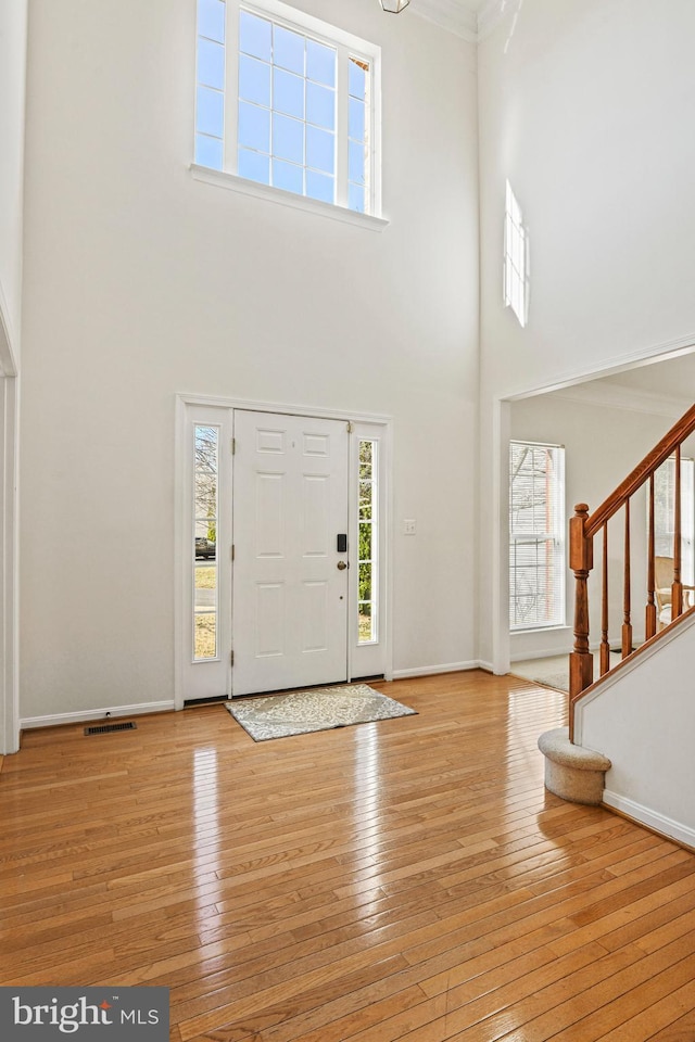 entrance foyer with baseboards, plenty of natural light, stairs, and hardwood / wood-style flooring