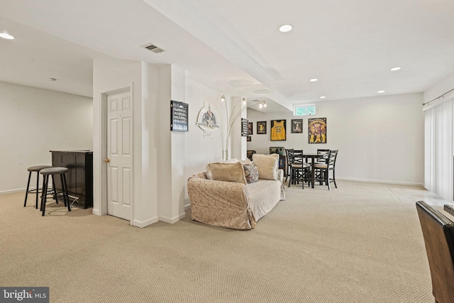 carpeted living area featuring visible vents, a dry bar, recessed lighting, and baseboards