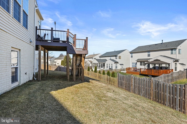 view of yard featuring stairs, a fenced backyard, a residential view, and a wooden deck