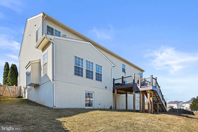 back of property featuring stairs, fence, a lawn, and a wooden deck