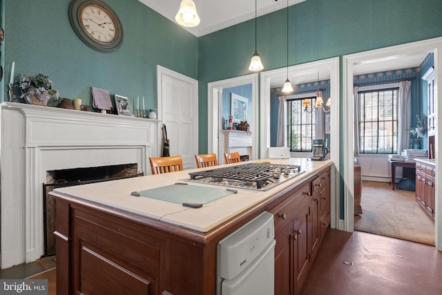 kitchen featuring a breakfast bar, dishwasher, hanging light fixtures, ornamental molding, and a kitchen island