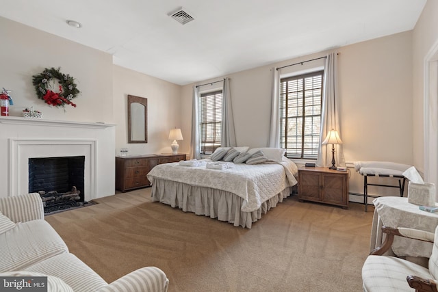 bedroom with light carpet and a baseboard heating unit