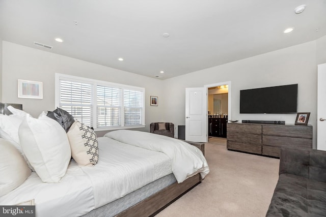 carpeted bedroom featuring ensuite bath