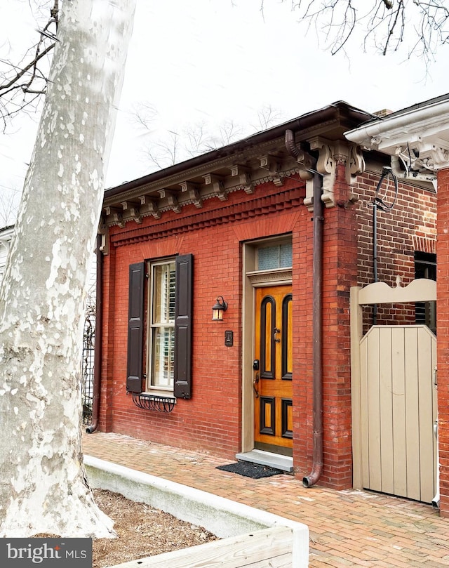 property entrance with brick siding and a gate