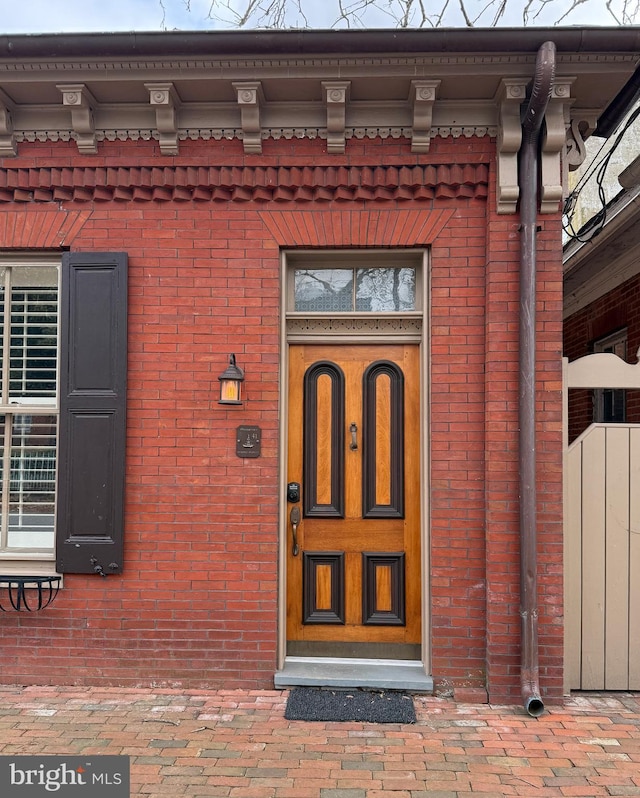 doorway to property with brick siding