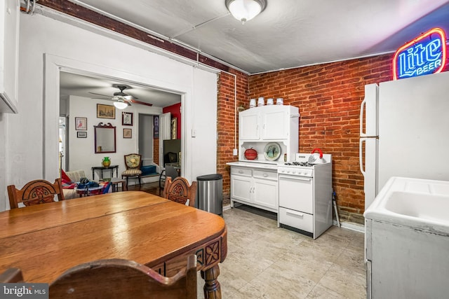 dining room featuring brick wall and ceiling fan