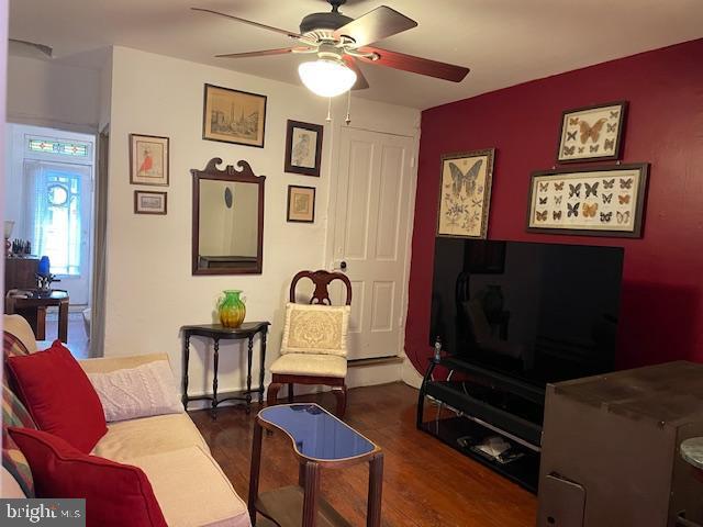 living room featuring dark hardwood / wood-style flooring and ceiling fan