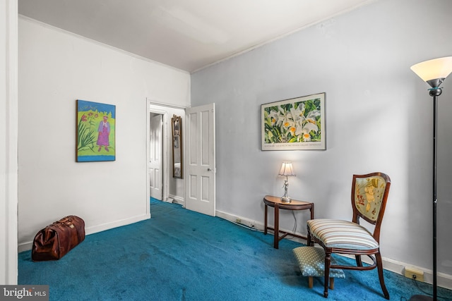 living area featuring ornamental molding and carpet flooring