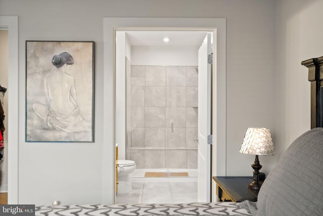 bathroom featuring tile patterned floors, toilet, and tiled shower