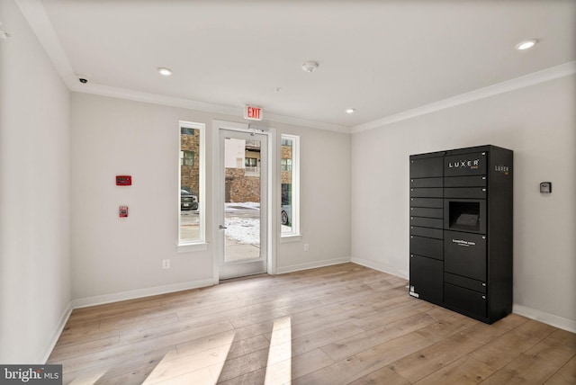 spare room featuring crown molding and light hardwood / wood-style flooring