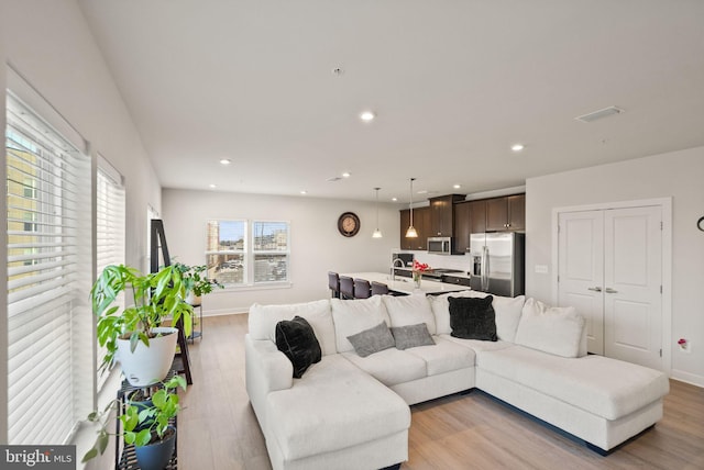 living room with sink and light wood-type flooring