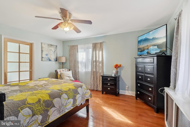 bedroom with light wood-type flooring, baseboards, and a ceiling fan