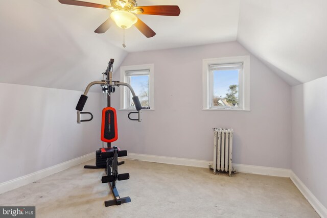 exercise room featuring radiator, baseboards, carpet flooring, and lofted ceiling