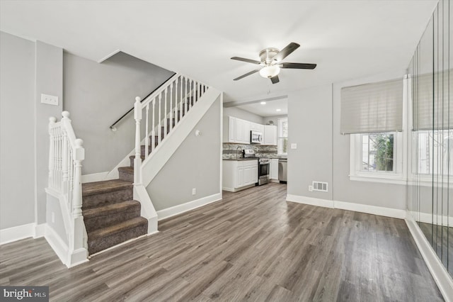 unfurnished living room with hardwood / wood-style floors and ceiling fan