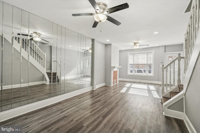 unfurnished living room featuring dark wood-type flooring and ceiling fan