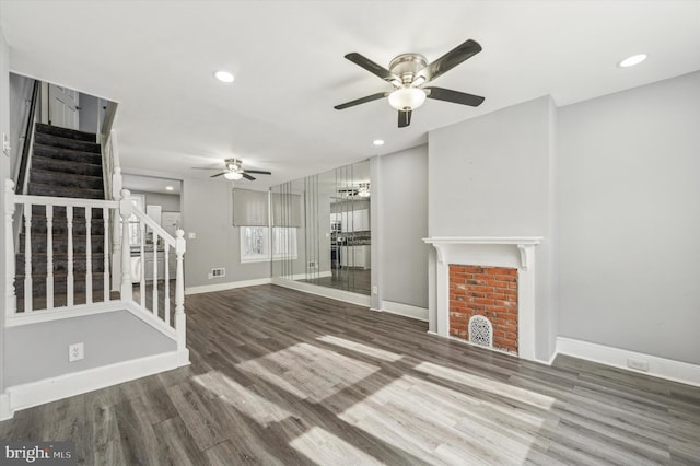 unfurnished living room with ceiling fan, a fireplace, and hardwood / wood-style floors