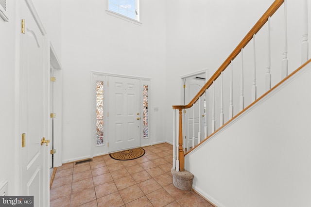 tiled foyer with a towering ceiling