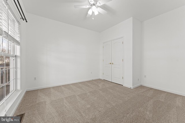 spare room with light carpet and ceiling fan